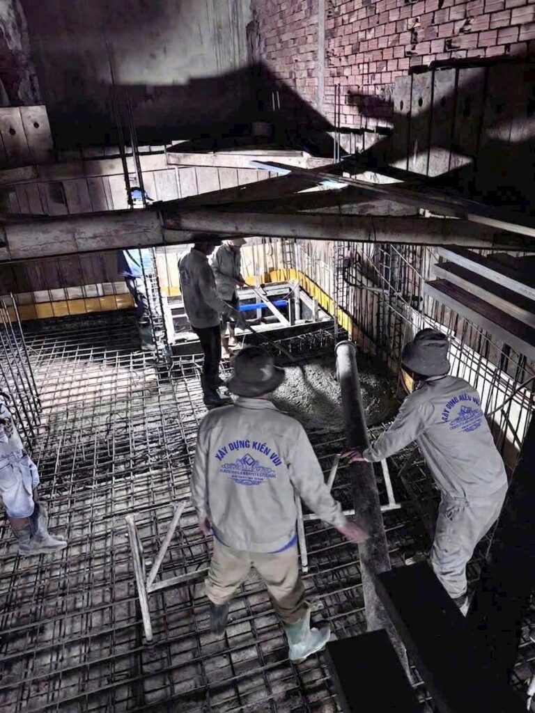 Công nhân thi công đổ bê tông sàn trên hệ cốt thép và cốp pha bên trong công trình nhà ở.
